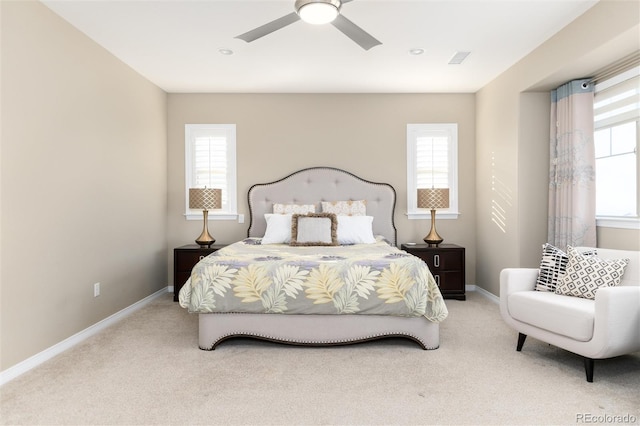 carpeted bedroom with multiple windows and ceiling fan