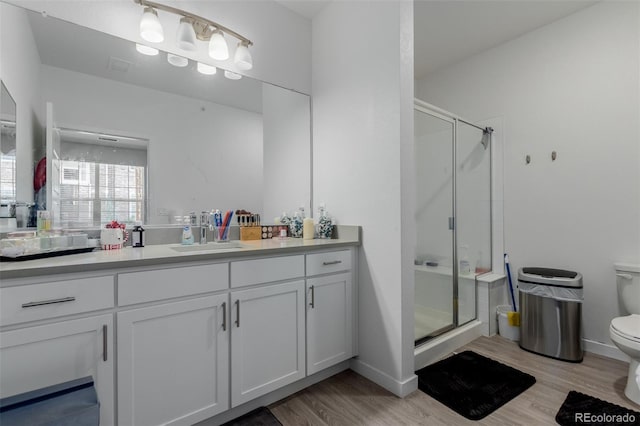 9185 Wilde Ln Unit 101, Parker, CO 80134 - bathroom featuring toilet, a stall shower, vanity, wood finished floors, and baseboards