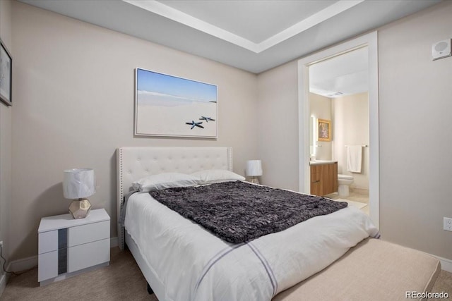 carpeted bedroom featuring ensuite bath