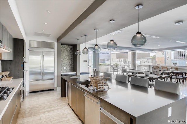 kitchen with stainless steel appliances, a healthy amount of sunlight, a spacious island, and hanging light fixtures