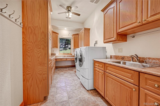 washroom with cabinets, washing machine and dryer, ceiling fan, and sink