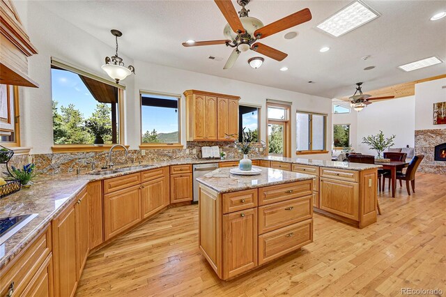 kitchen featuring dishwasher, pendant lighting, a kitchen island, and sink