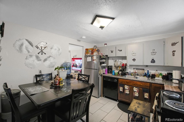 kitchen featuring sink, light tile patterned floors, black appliances, a textured ceiling, and white cabinets