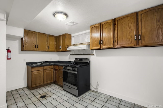 kitchen with sink, gas range, and light tile patterned floors