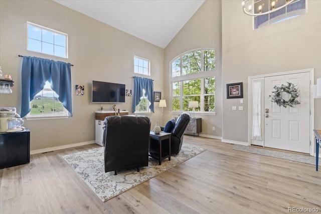 17102 W 85th Pl, Arvada, CO 80007 - living room with high vaulted ceiling, wood finished floors, a chandelier, plenty of natural light, and baseboards