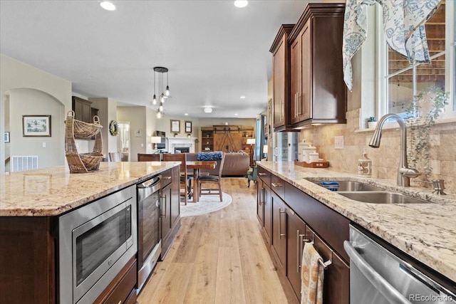 17102 W 85th Pl, Arvada, CO 80007 - kitchen with stainless steel appliances, a sink, beverage cooler, light wood finished floors, and open floor plan