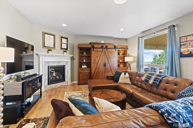 17102 W 85th Pl, Arvada, CO 80007 - living area featuring a tiled fireplace, wood finished floors, a barn door, and recessed lighting