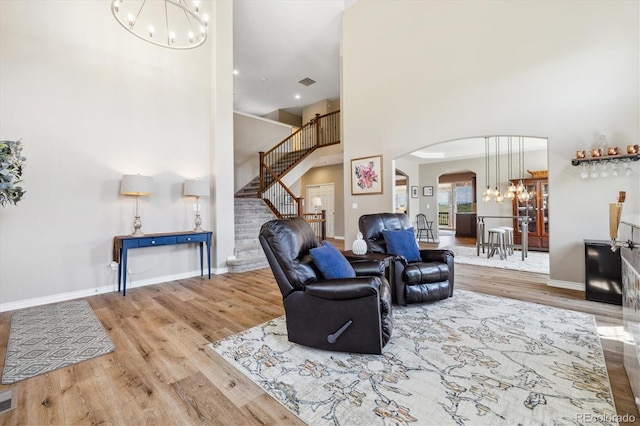 17102 W 85th Pl, Arvada, CO 80007 - living area with a chandelier, a towering ceiling, arched walkways, stairs, and wood finished floors