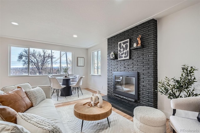 living area with recessed lighting, baseboards, wood finished floors, and a fireplace