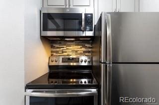 kitchen with white cabinets, stainless steel appliances, and backsplash