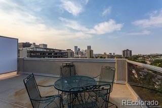 view of patio / terrace featuring a view of city, outdoor dining area, and a balcony