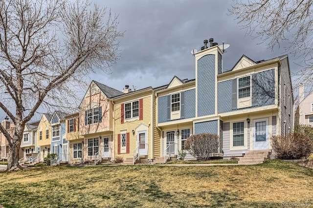 view of front of property with a chimney, a front lawn, and entry steps
