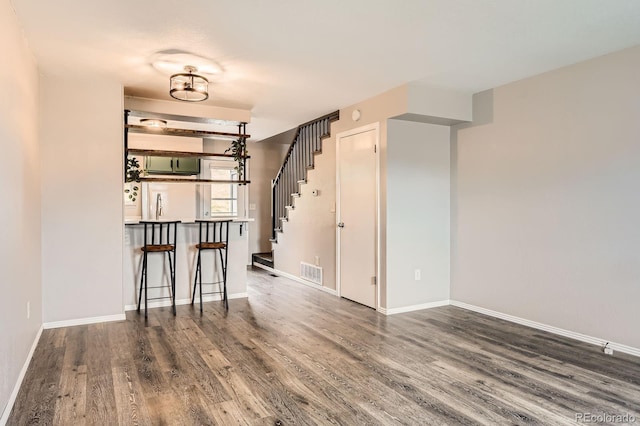 interior space with baseboards, visible vents, stairway, and wood finished floors
