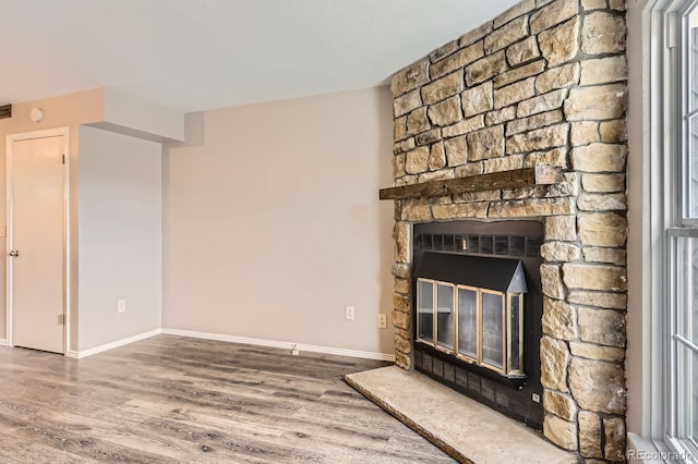 unfurnished living room with baseboards and wood finished floors