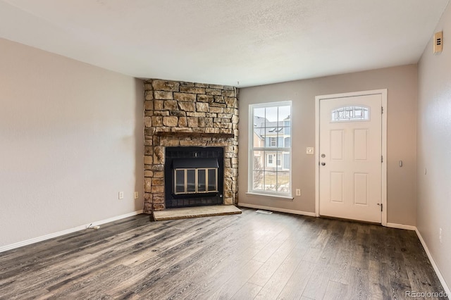 unfurnished living room featuring baseboards, a fireplace, and wood finished floors