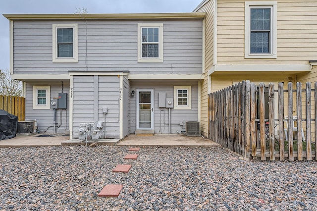 rear view of property featuring fence, cooling unit, and a patio