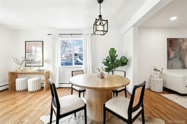 dining room featuring baseboard heating and light hardwood / wood-style flooring