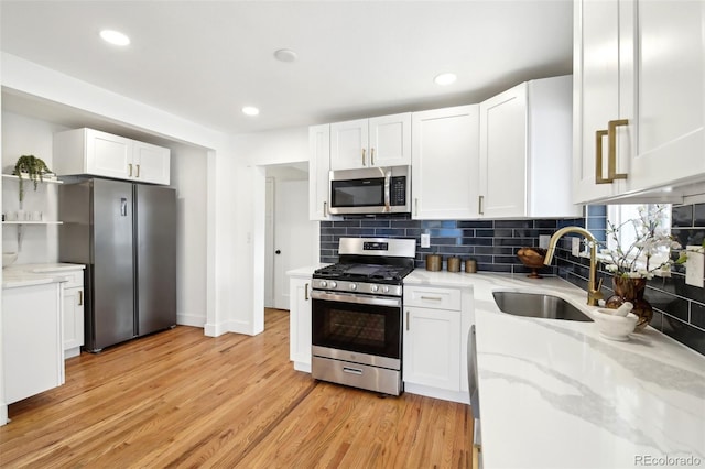 kitchen featuring appliances with stainless steel finishes, sink, and white cabinets