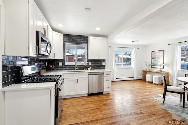 kitchen with white cabinetry, sink, stainless steel appliances, and light wood-type flooring