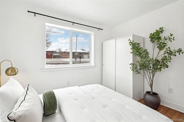 bedroom with hardwood / wood-style floors and a closet