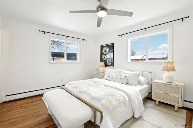 bedroom featuring baseboard heating, ceiling fan, and hardwood / wood-style flooring