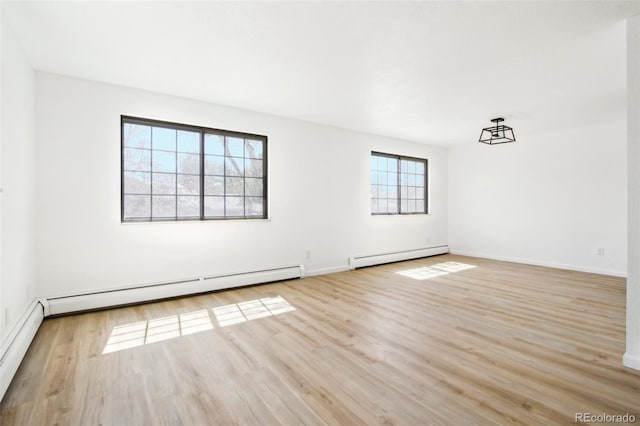 unfurnished room with baseboards, wood finished floors, and baseboard heating
