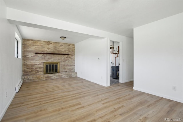 unfurnished living room featuring a brick fireplace, baseboards, wood finished floors, and baseboard heating