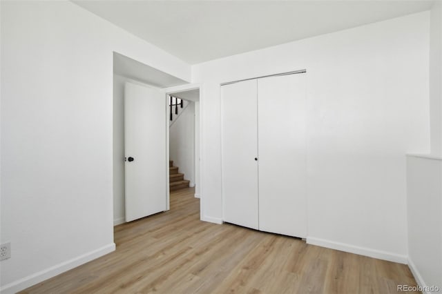 unfurnished bedroom with a closet, baseboards, and wood finished floors