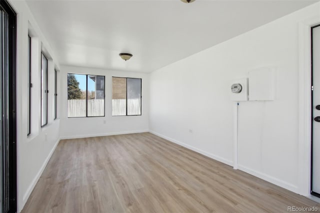 spare room with light wood-style floors and baseboards
