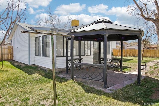 exterior space featuring a gazebo, a patio, fence, and a lawn