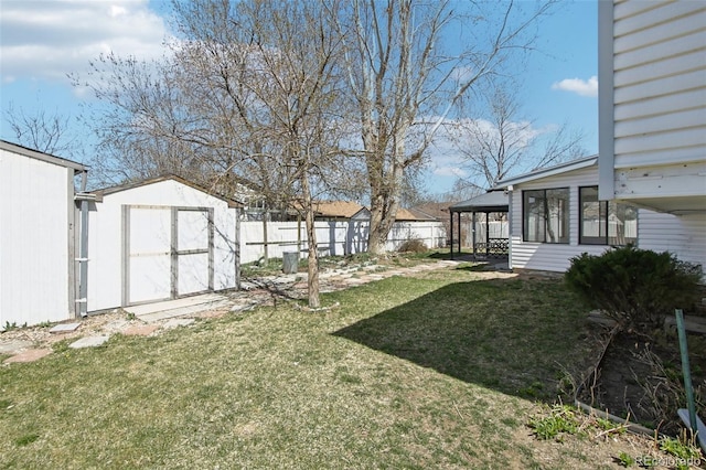 view of yard with an outbuilding, a storage unit, and a fenced backyard