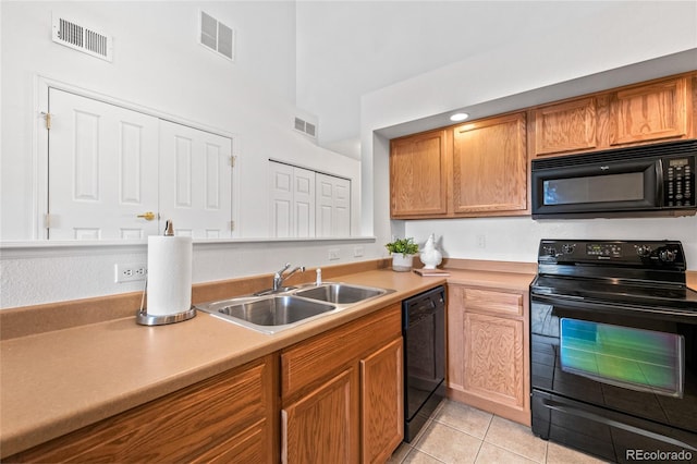 kitchen with light tile patterned floors, sink, and black appliances