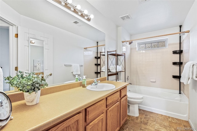 full bathroom with tiled shower / bath, vanity, and toilet