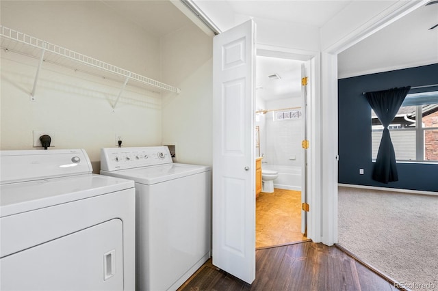 clothes washing area featuring washing machine and clothes dryer and dark hardwood / wood-style flooring