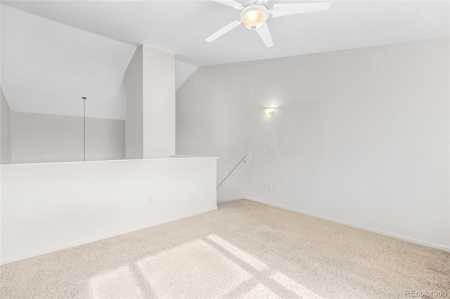 carpeted spare room with ceiling fan and lofted ceiling