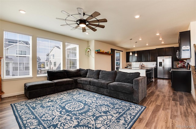 living room with sink, hardwood / wood-style flooring, and ceiling fan