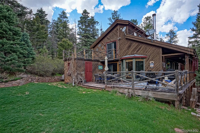 rear view of house with a yard and a wooden deck