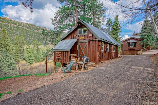 view of front of home featuring a mountain view and an outdoor structure