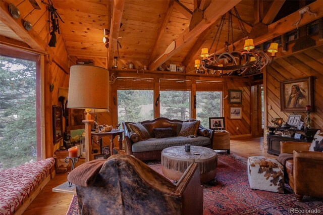 living room with wooden walls, hardwood / wood-style flooring, lofted ceiling with beams, wooden ceiling, and a notable chandelier