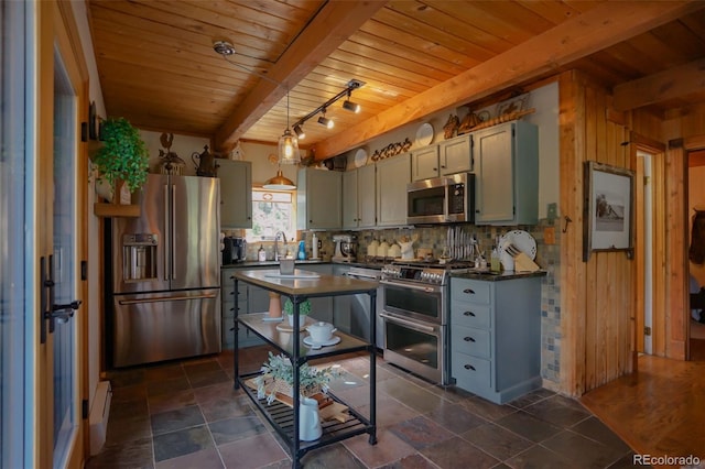 kitchen with pendant lighting, high quality appliances, wood walls, and beam ceiling