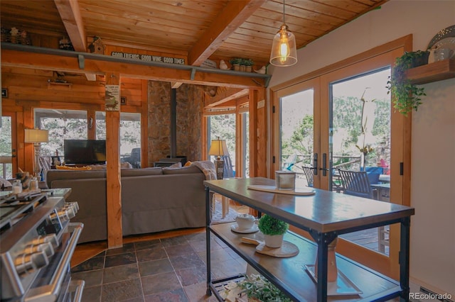 dining area featuring french doors, wood ceiling, plenty of natural light, and a wood stove