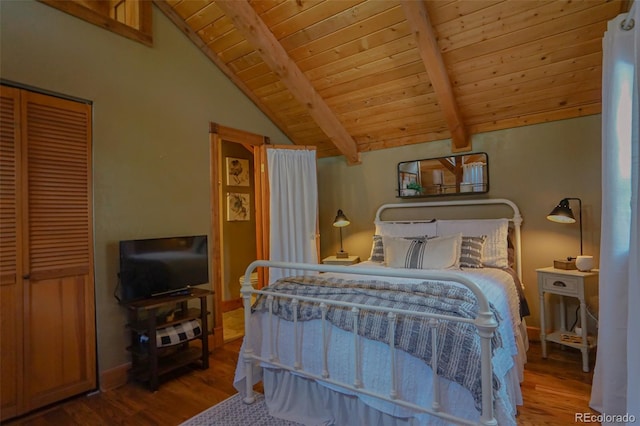 bedroom with lofted ceiling with beams, a closet, wooden ceiling, and hardwood / wood-style floors