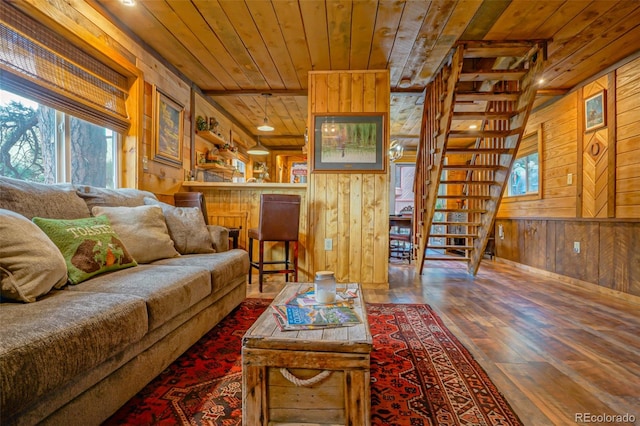 living room with wooden walls, dark hardwood / wood-style floors, and wood ceiling