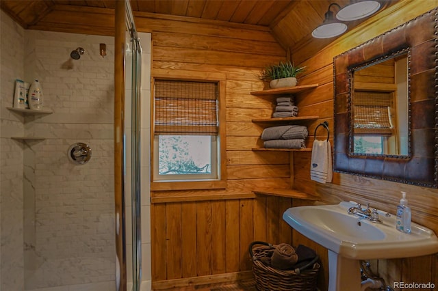 bathroom featuring wood ceiling, lofted ceiling, wooden walls, sink, and a shower with door