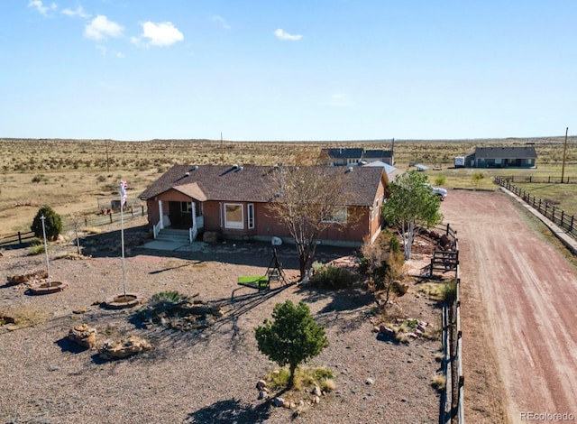 1882 N Rough Rock Ln, Pueblo West, CO 81007 - view of front facade with a view of countryside, fence, and dirt driveway