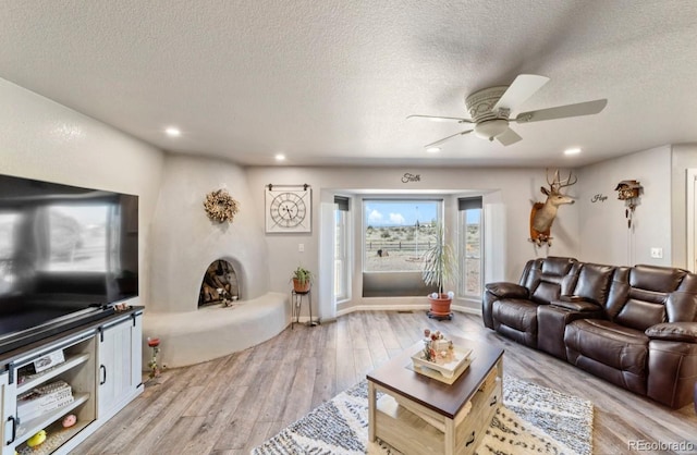 1882 N Rough Rock Ln, Pueblo West, CO 81007 - living room featuring a textured ceiling, ceiling fan, light wood finished floors, and recessed lighting