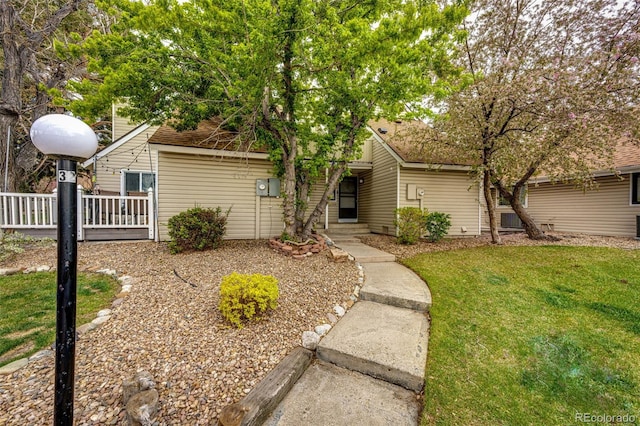 view of front of home with roof with shingles and a front lawn