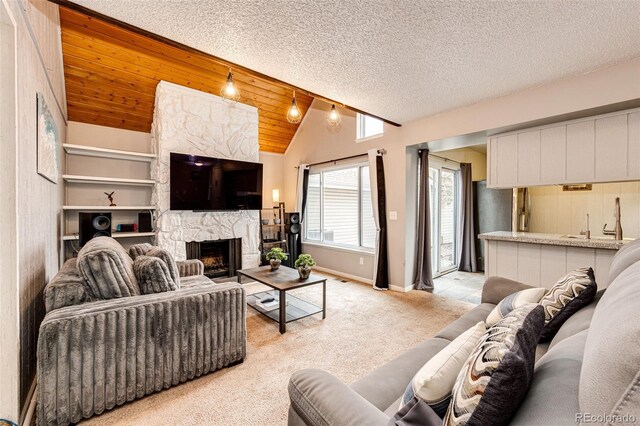 living room featuring baseboards, a stone fireplace, light carpet, and vaulted ceiling