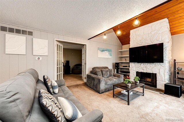 carpeted living room featuring vaulted ceiling, visible vents, and a stone fireplace