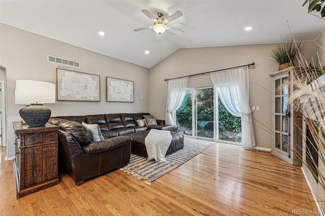 living room with light hardwood / wood-style flooring, vaulted ceiling, and ceiling fan